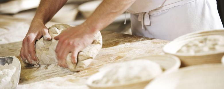 Boulanger qui pétrit de la pâte à pain